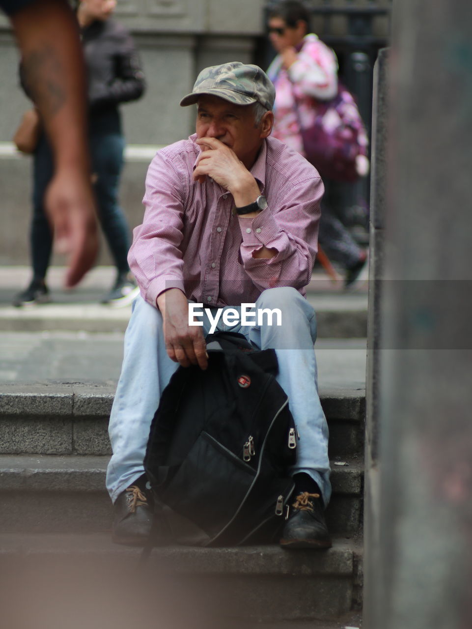 MIDSECTION OF MAN SITTING WITH WOMAN IN BACKGROUND