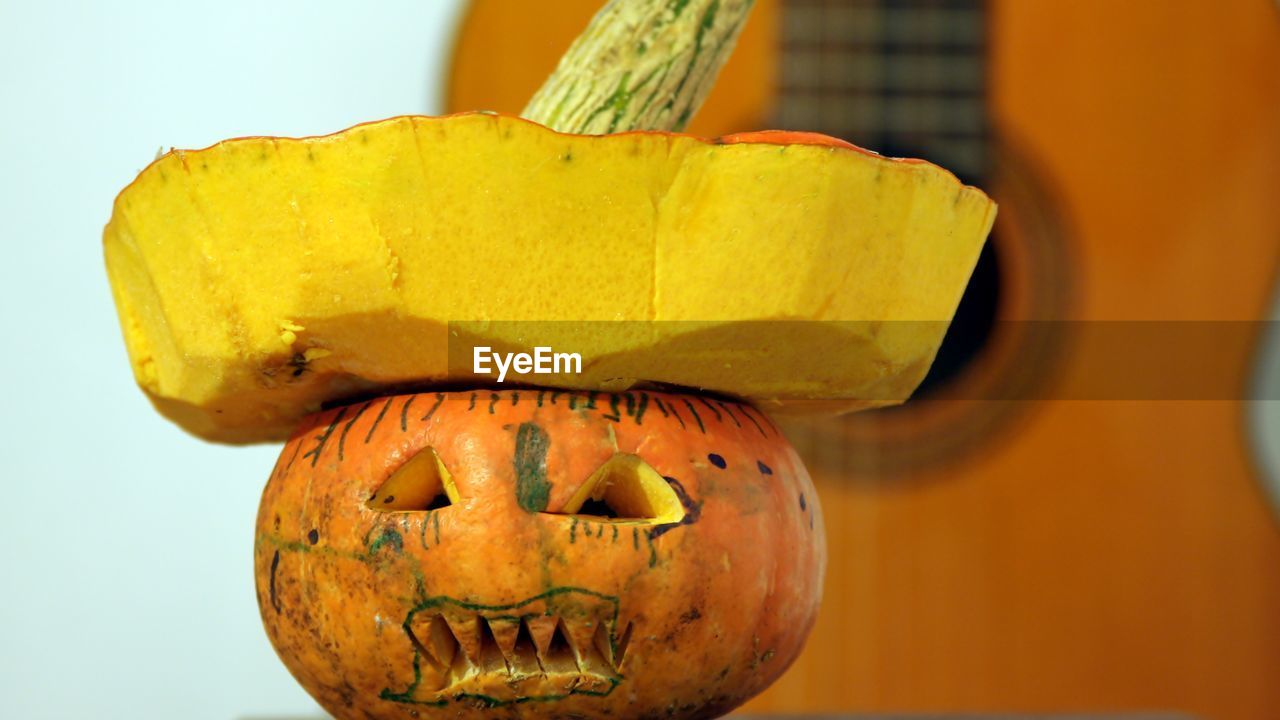 CLOSE-UP VIEW OF PUMPKIN AGAINST YELLOW WALL