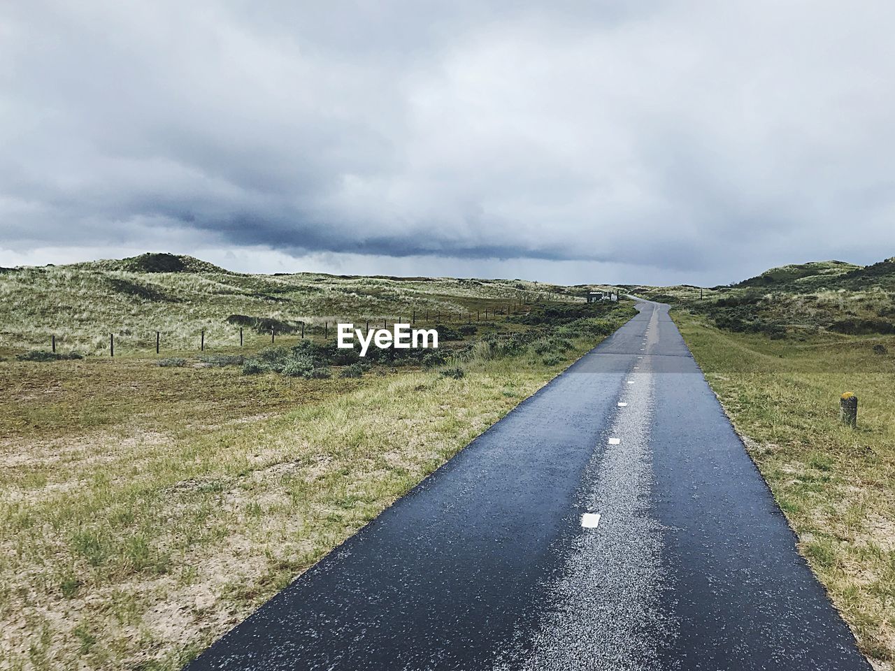 EMPTY ROAD ALONG COUNTRYSIDE LANDSCAPE