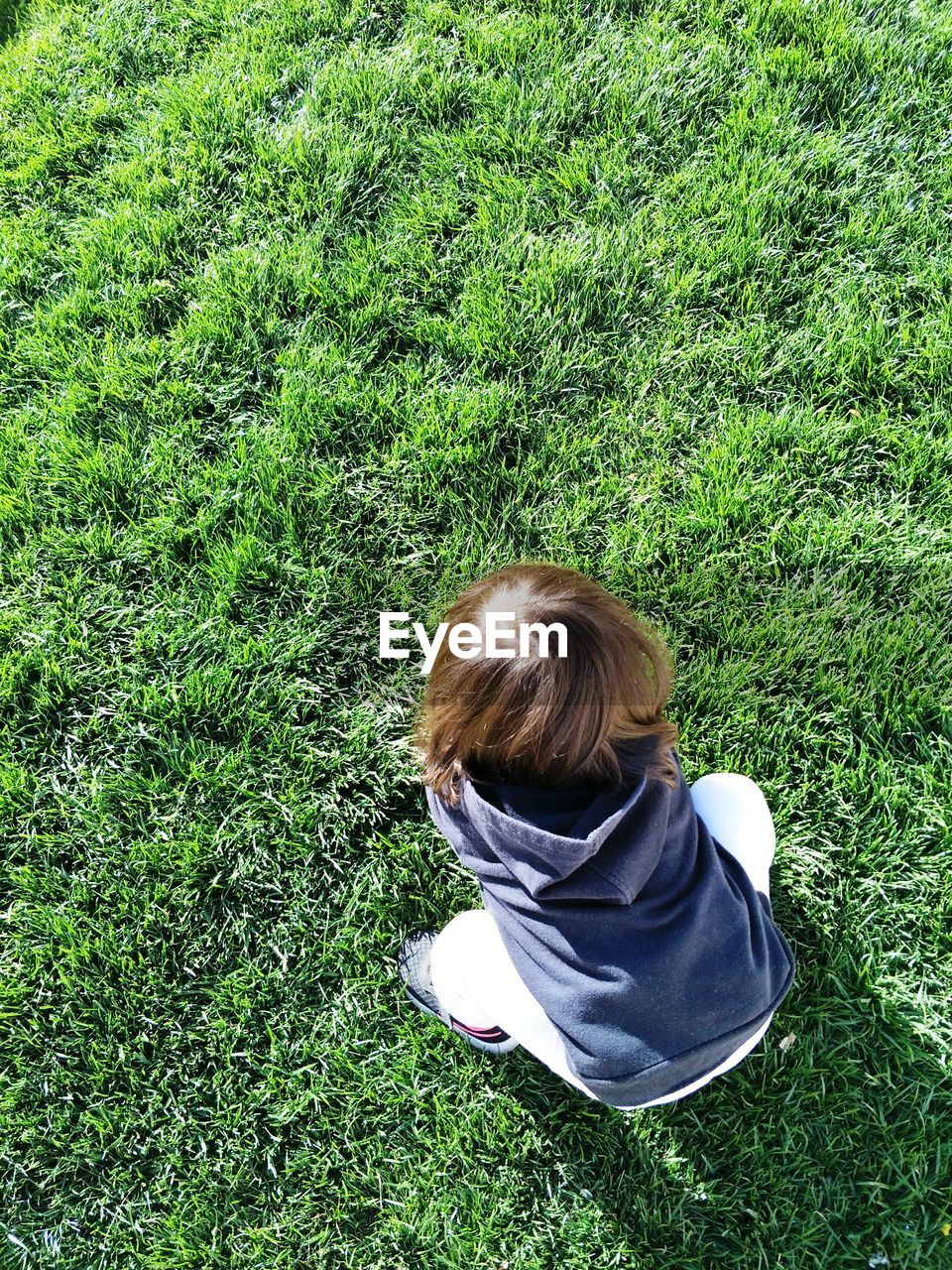 REAR VIEW OF BOY ON FIELD