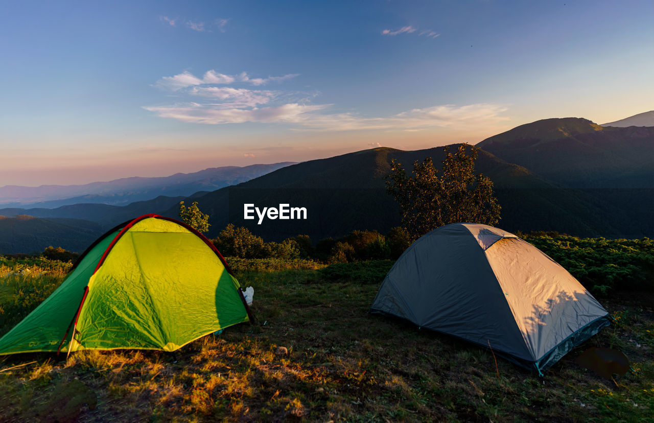 Camping tents in front of a beautiful mountain landscape