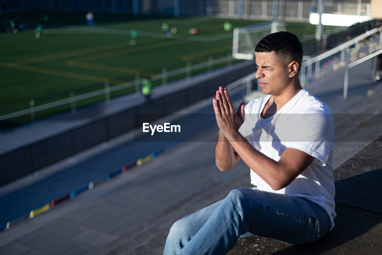 young man using mobile phone while sitting on chair