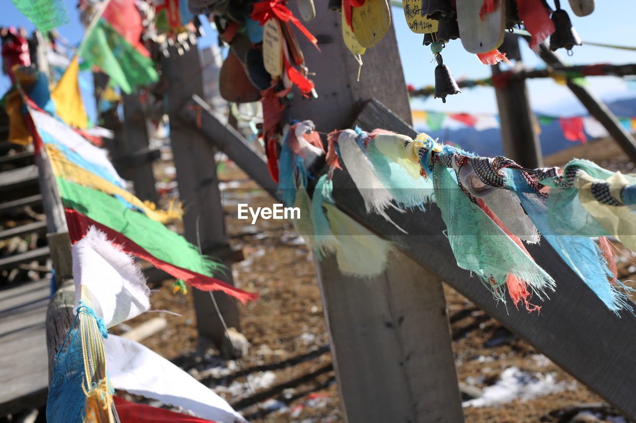 CLOSE-UP OF MULTI COLORED FLAGS ON FENCE