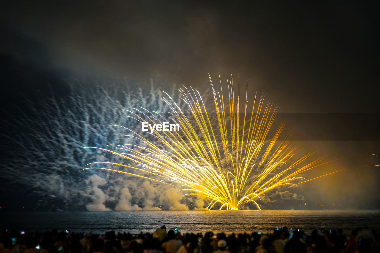 FIREWORK DISPLAY OVER WATER AT NIGHT