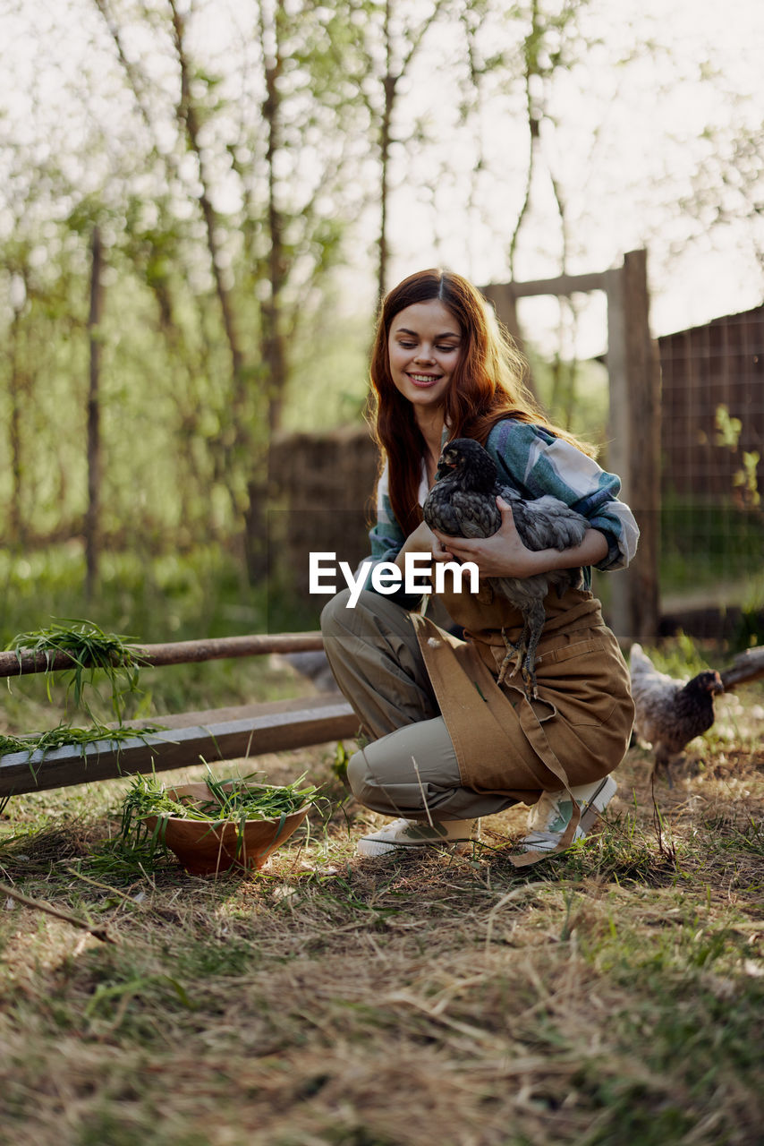 side view of young woman sitting on grass