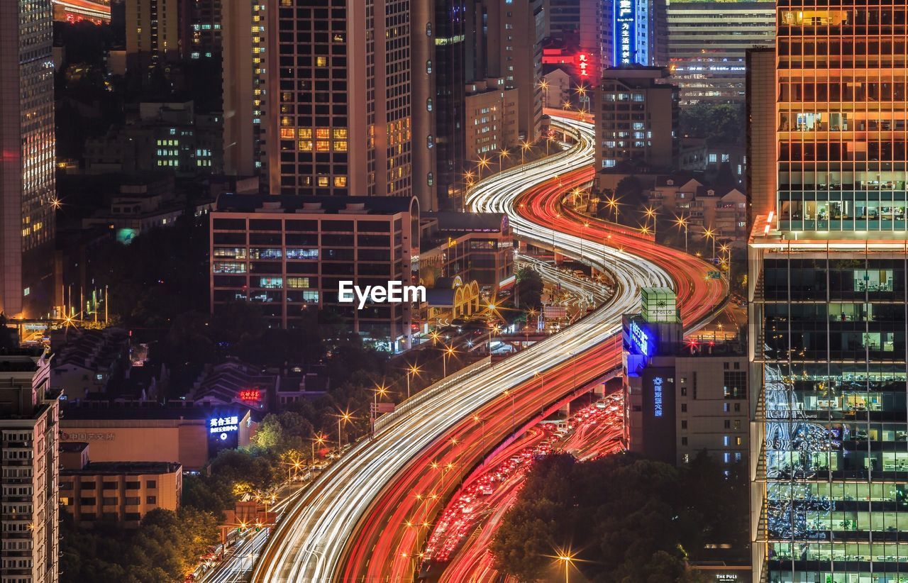 Light trails on road in illuminated city at night