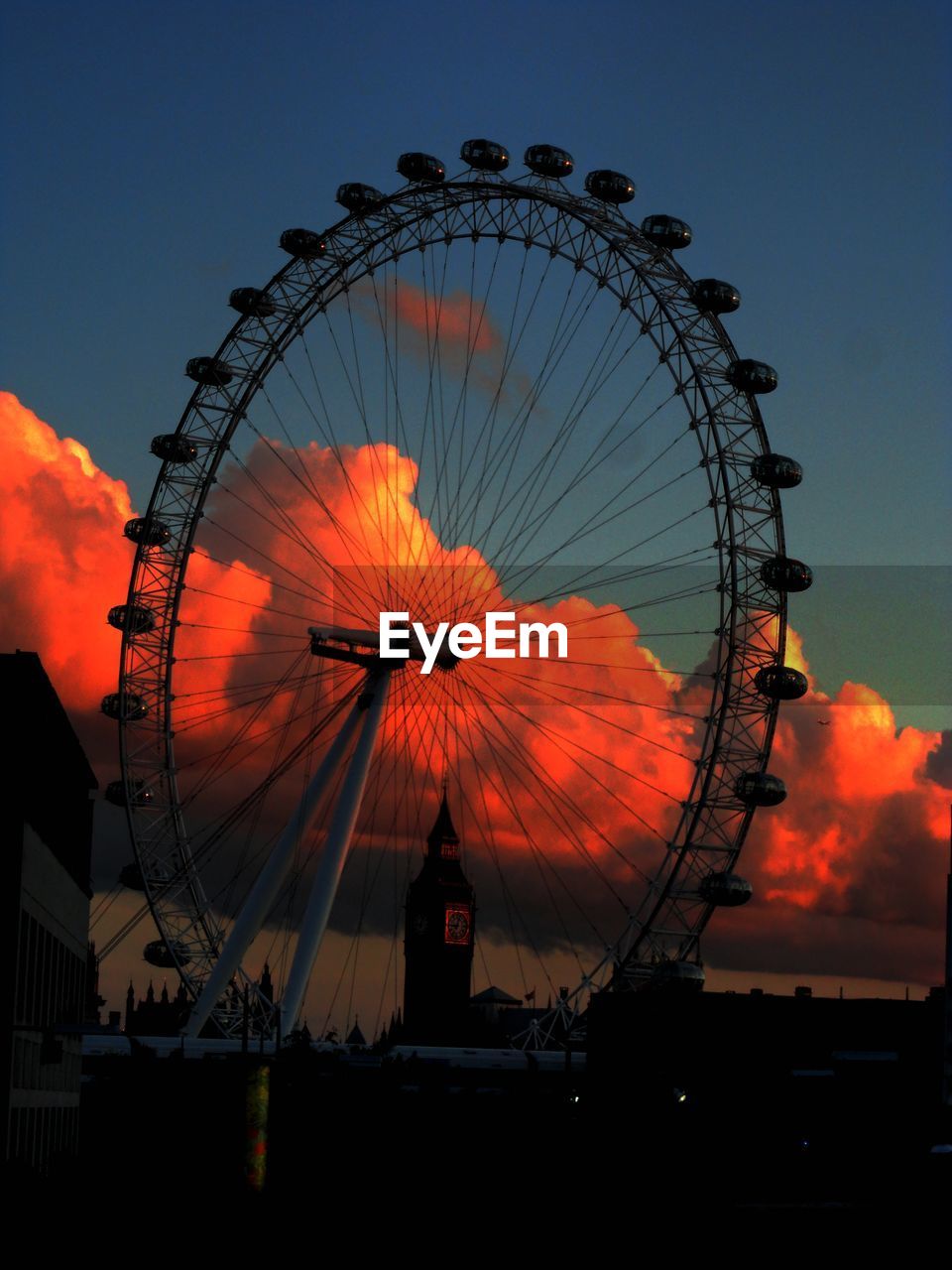 LOW ANGLE VIEW OF FERRIS WHEEL AGAINST SKY AT SUNSET