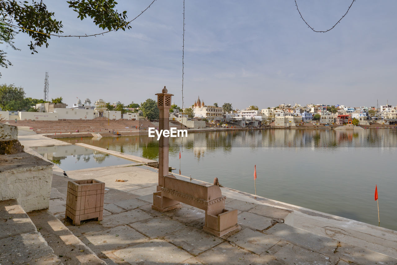 Scenic view of lake by buildings against sky