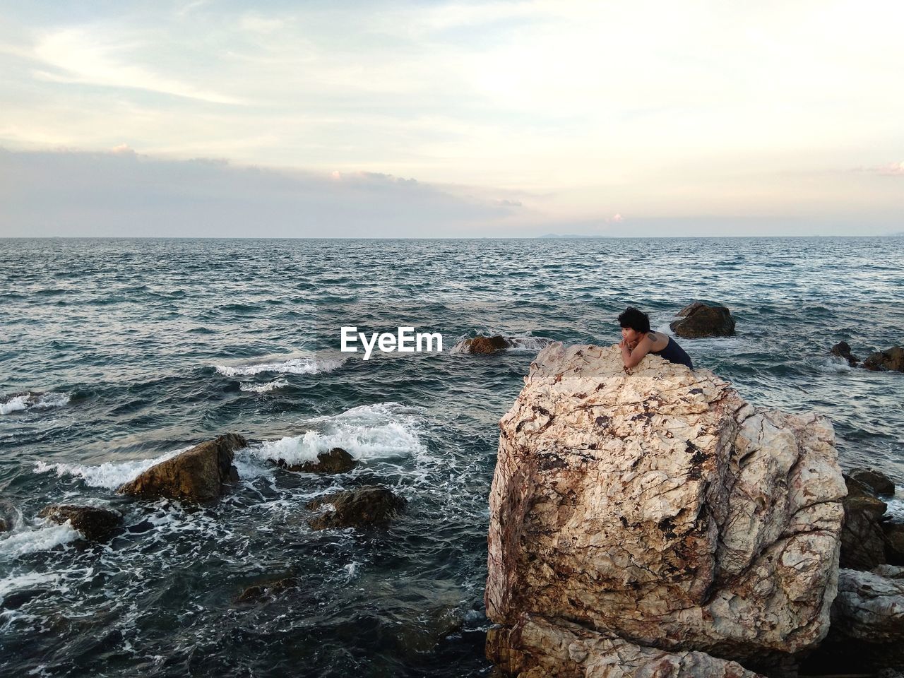 Young women on a rock watching sunset and imagining about sex tonight 