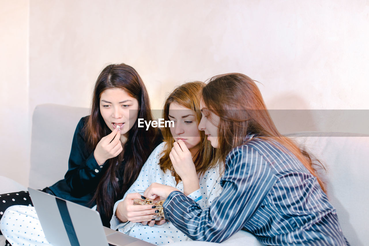 Female friends looking at laptop at home