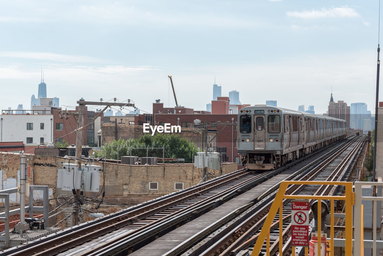 TRAIN IN CITY AGAINST SKY