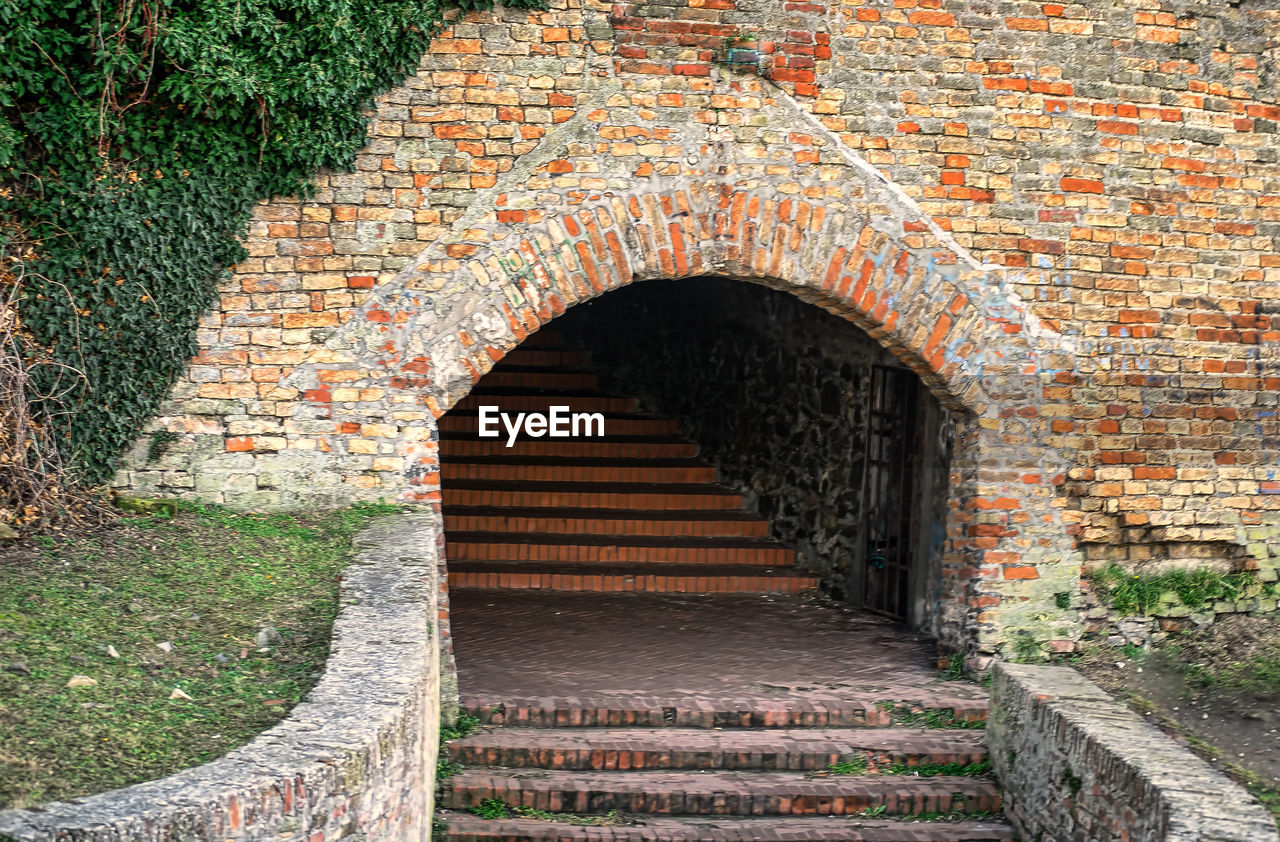 architecture, built structure, arch, staircase, no people, the way forward, wall, day, wall - building feature, brick, history, steps and staircases, building exterior, the past, old, entrance, ancient history, outdoors, building, brick wall, nature, plant, brickwork, footpath