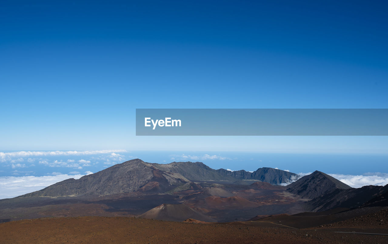 Scenic view of mountains against blue sky