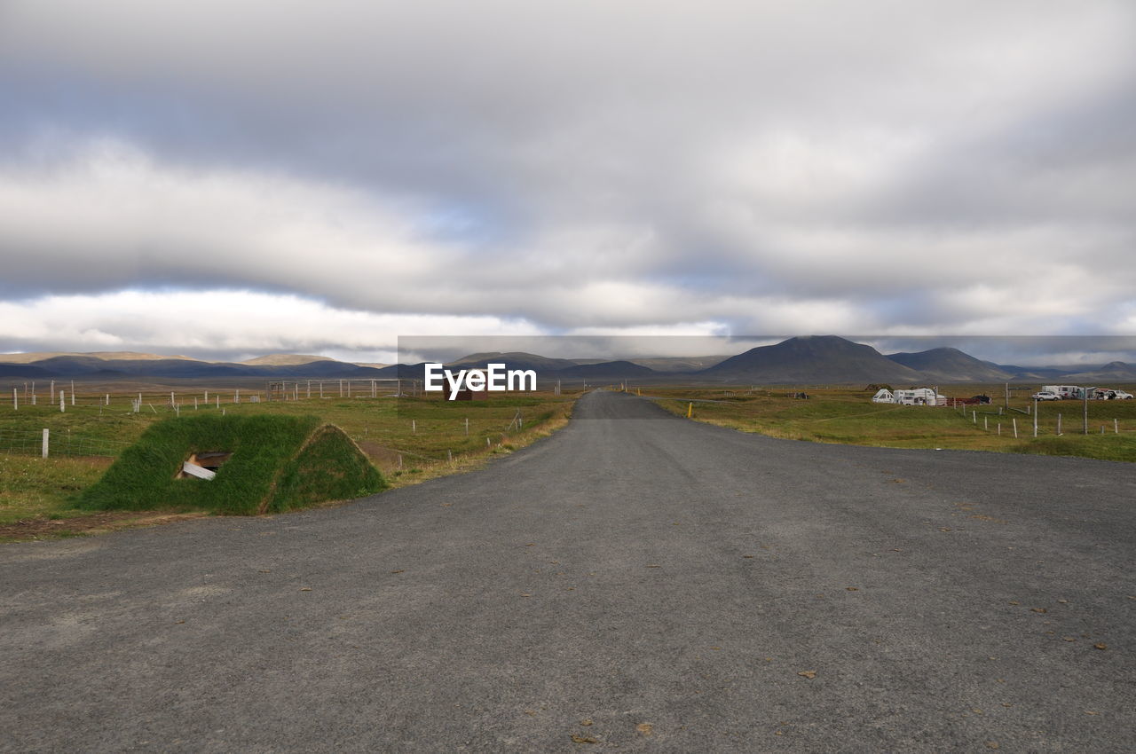 EMPTY ROAD WITH MOUNTAINS IN BACKGROUND