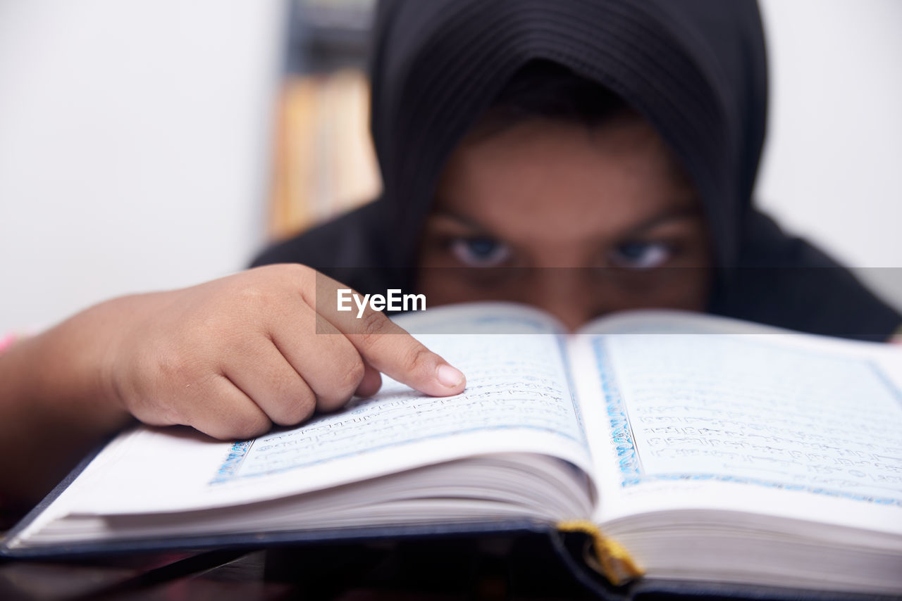 Cute muslim little girl reading koran