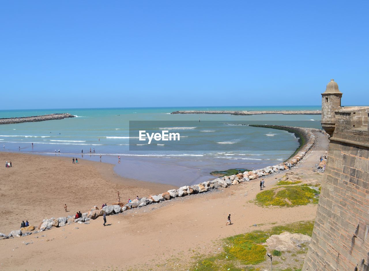 Scenic view of beach against clear blue sky