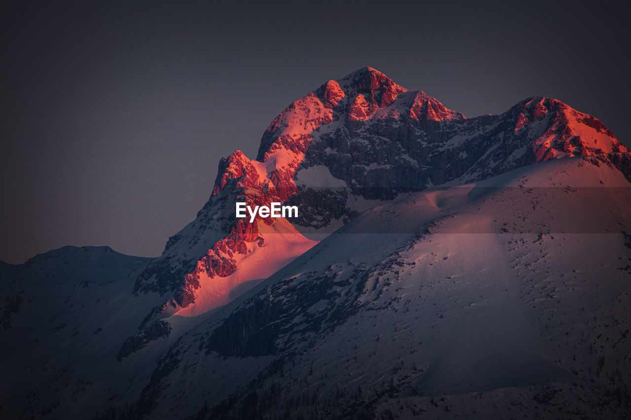 Scenic view of snowcapped mountains against sky at sunset