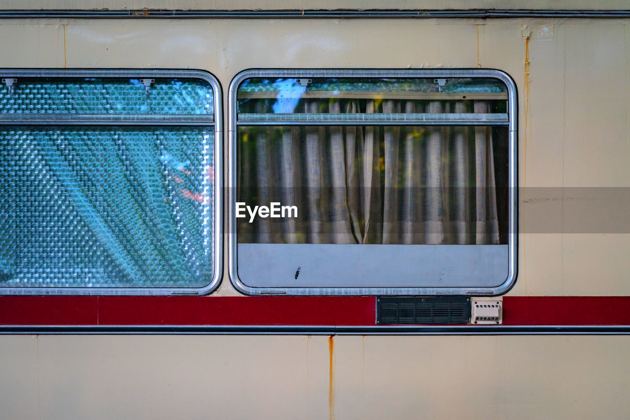 TRAIN AT RAILROAD STATION PLATFORM SEEN THROUGH WINDOW