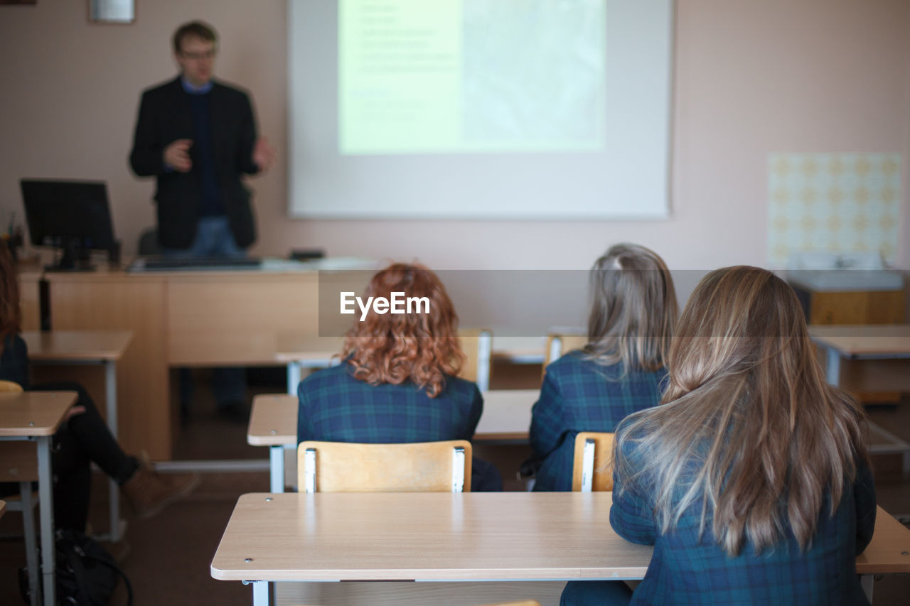 Rear view of students sitting in classroom