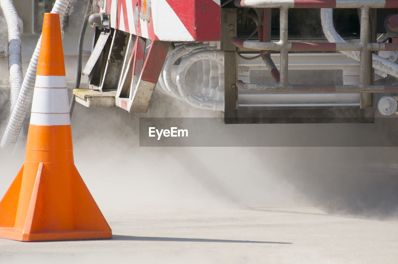 Traffic cone and machinery on road at construction site
