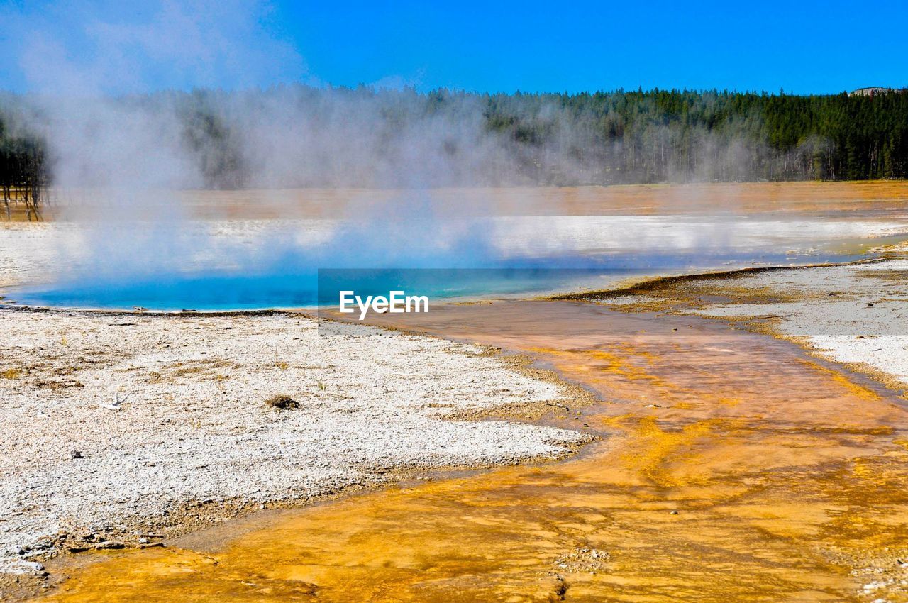 Scenic view of hot spring against sky