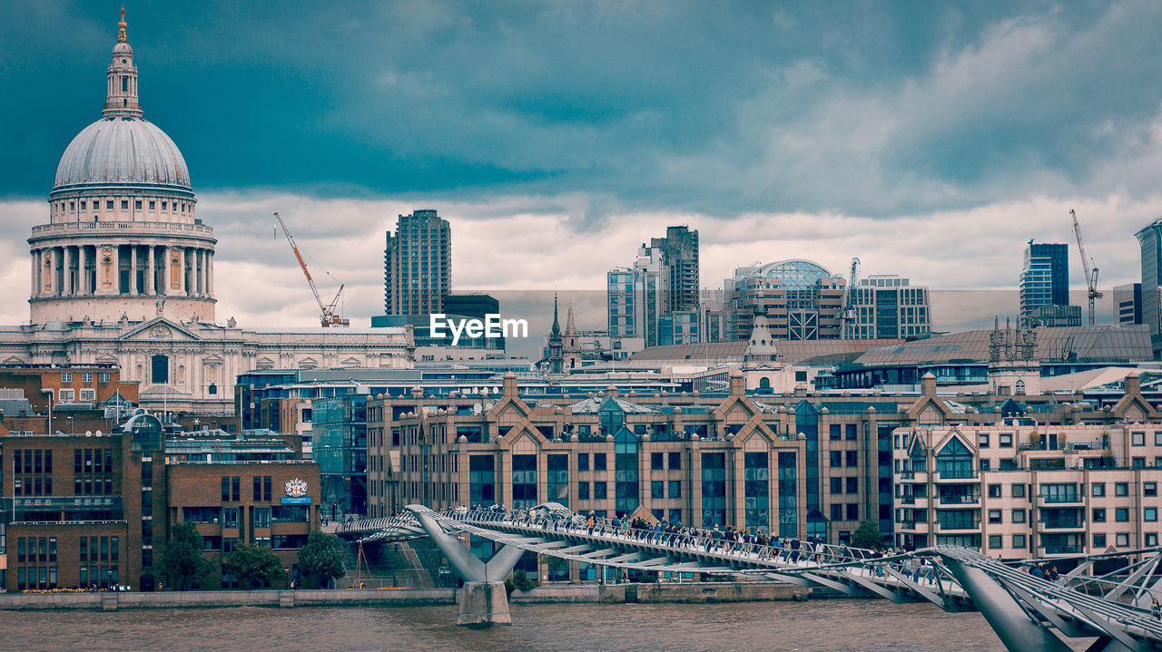 Modern buildings in city against cloudy sky