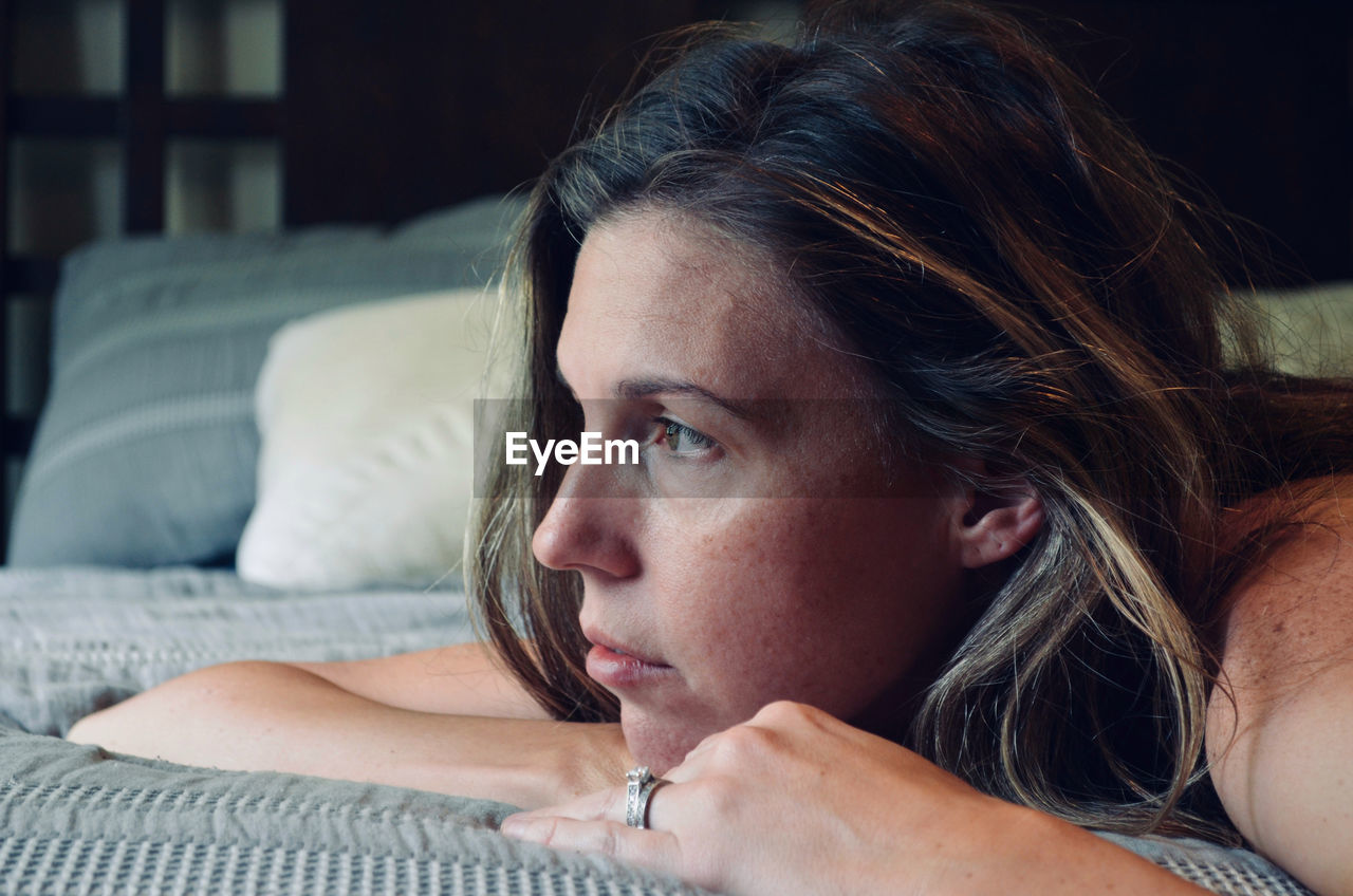 Portrait of beautiful woman lying down on a bed.