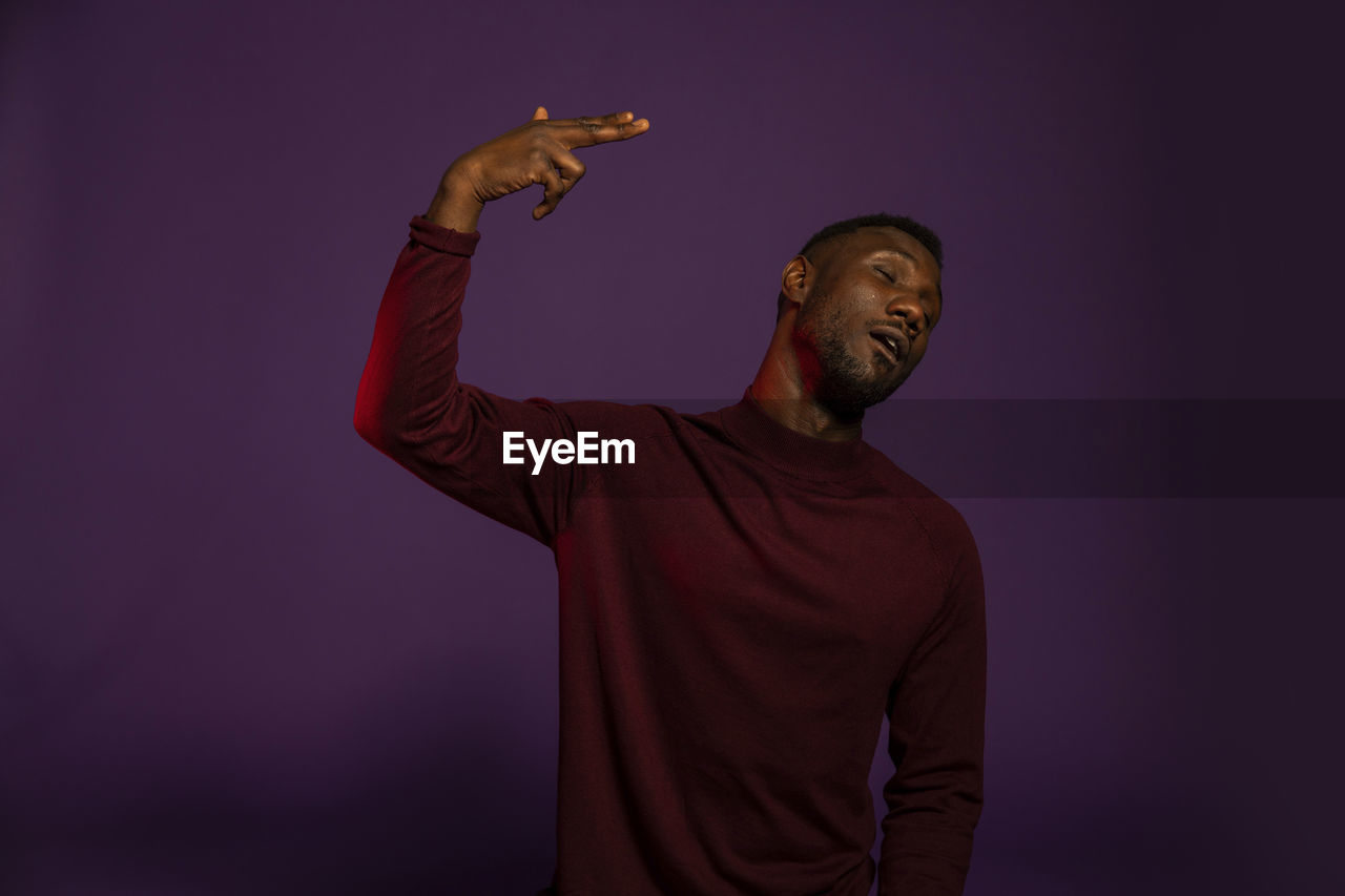 MAN LOOKING AT CAMERA OVER GRAY BACKGROUND