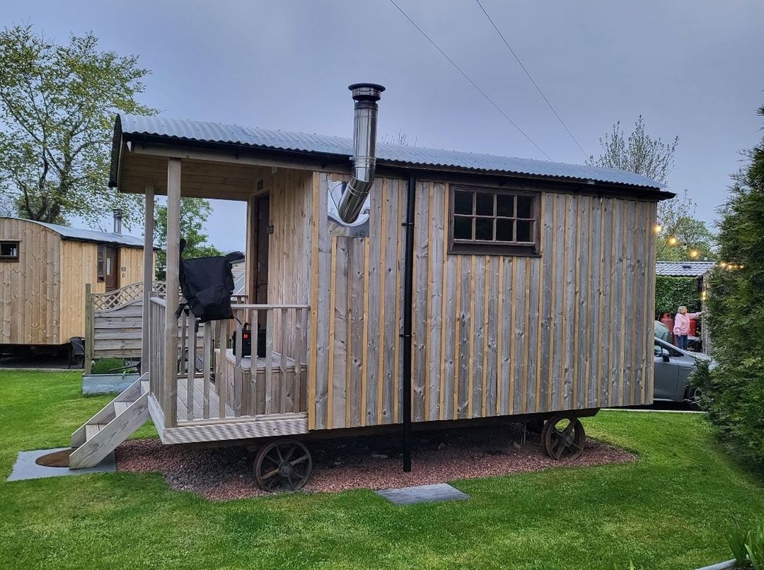 architecture, grass, building exterior, built structure, house, home, plant, shed, nature, building, sky, outdoor structure, front or back yard, cottage, shack, no people, backyard, day, residential district, wood, outdoors, yard, tree, vehicle