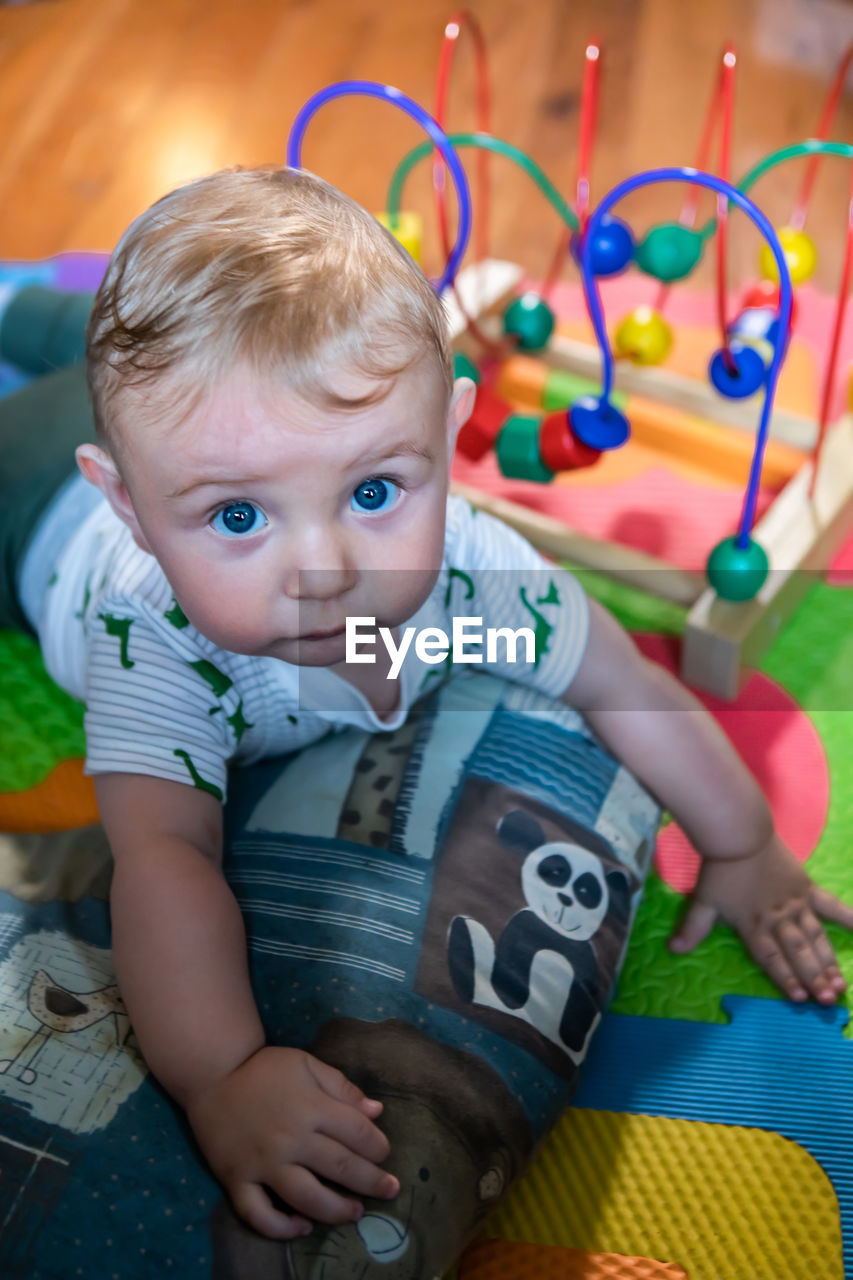 PORTRAIT OF CUTE BOY SITTING WITH TOY