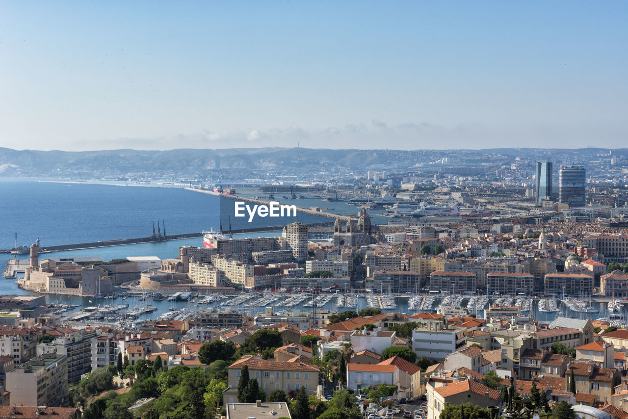 High angle view of buildings by sea against sky