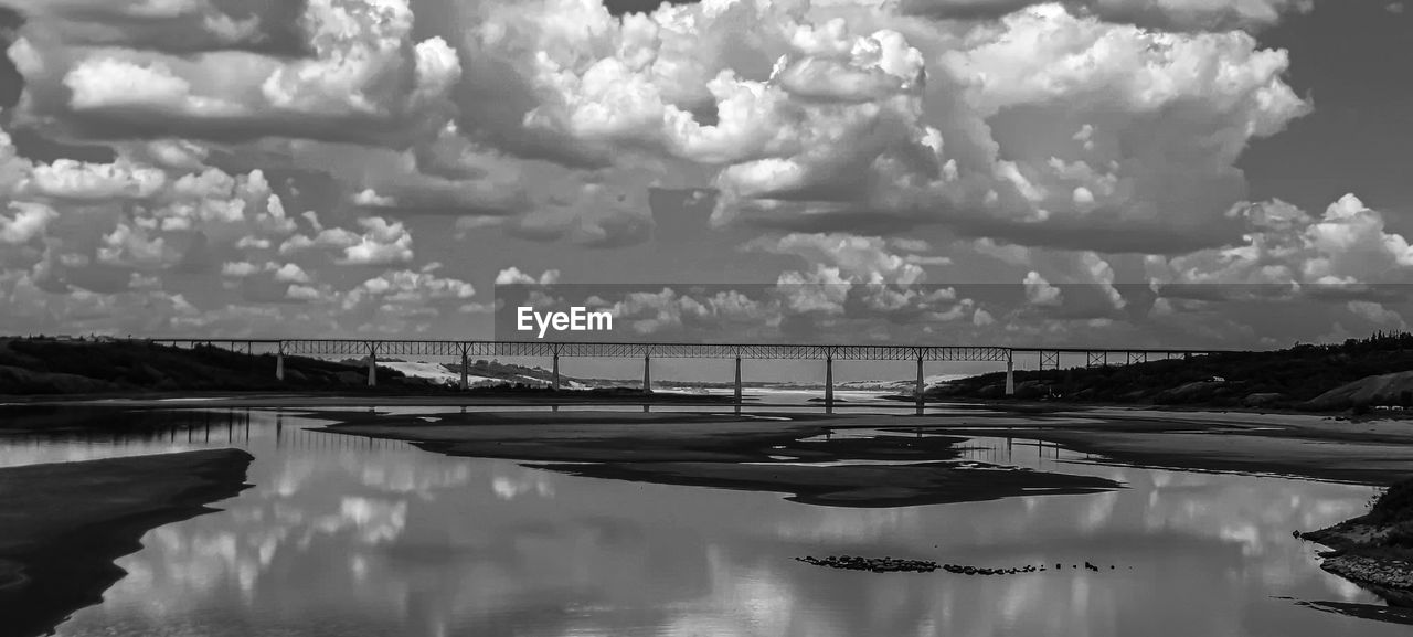 black and white, water, cloud, monochrome photography, monochrome, sky, reflection, nature, beauty in nature, scenics - nature, environment, no people, tranquility, sea, day, outdoors, tranquil scene, landscape, black, architecture, transportation, horizon