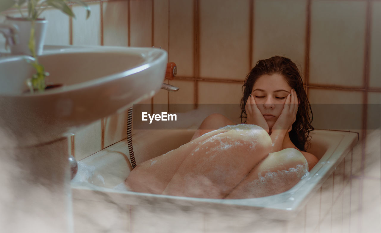 Woman looking away in bathroom at home