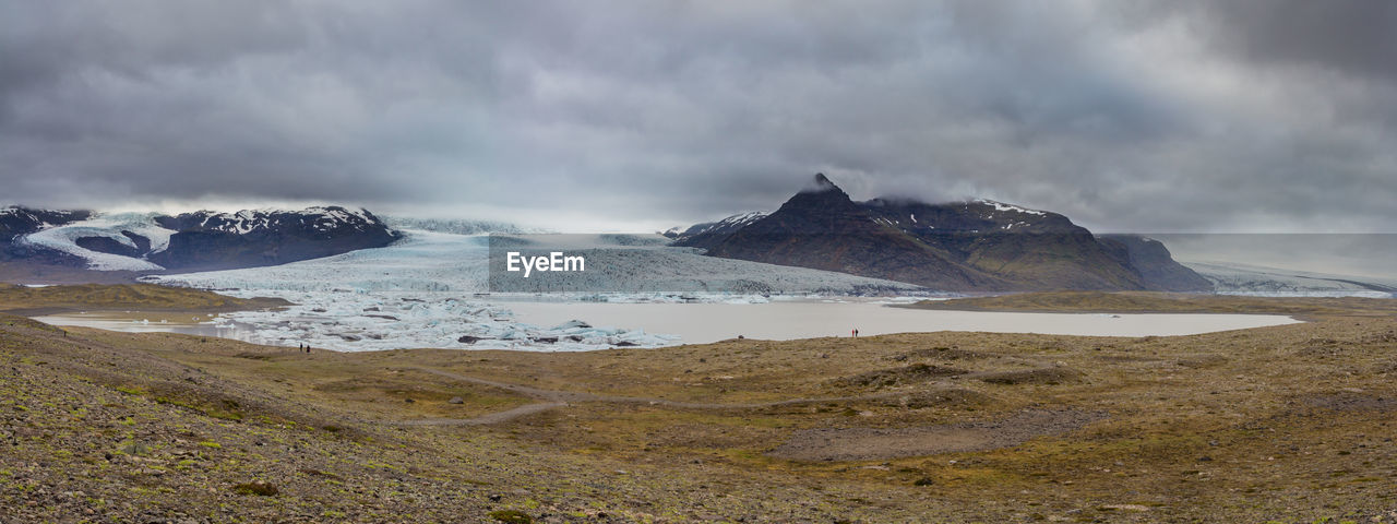 Fjallsarlon glacier slowly empties into a lake calving small icebergs during an icelandic summer