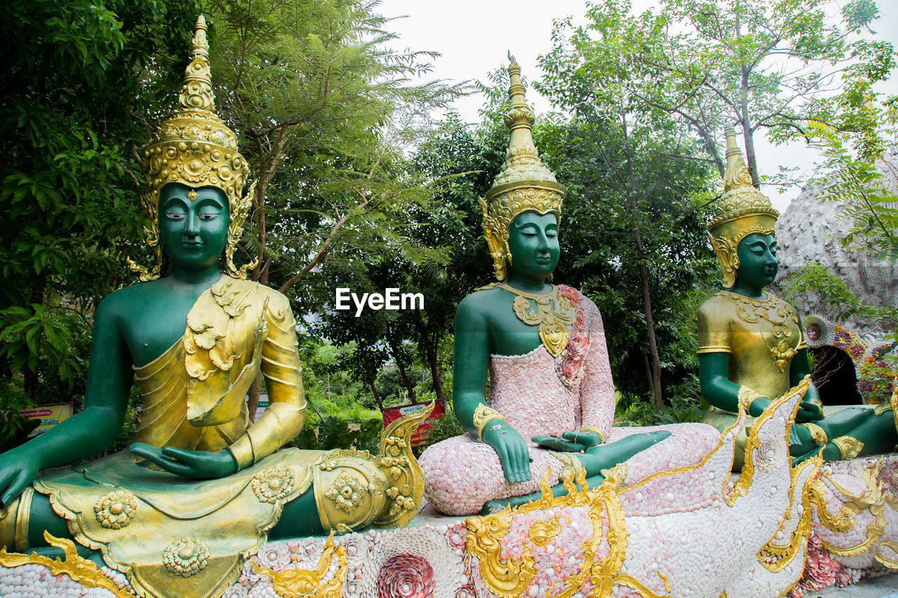 BUDDHA STATUE AGAINST TREES