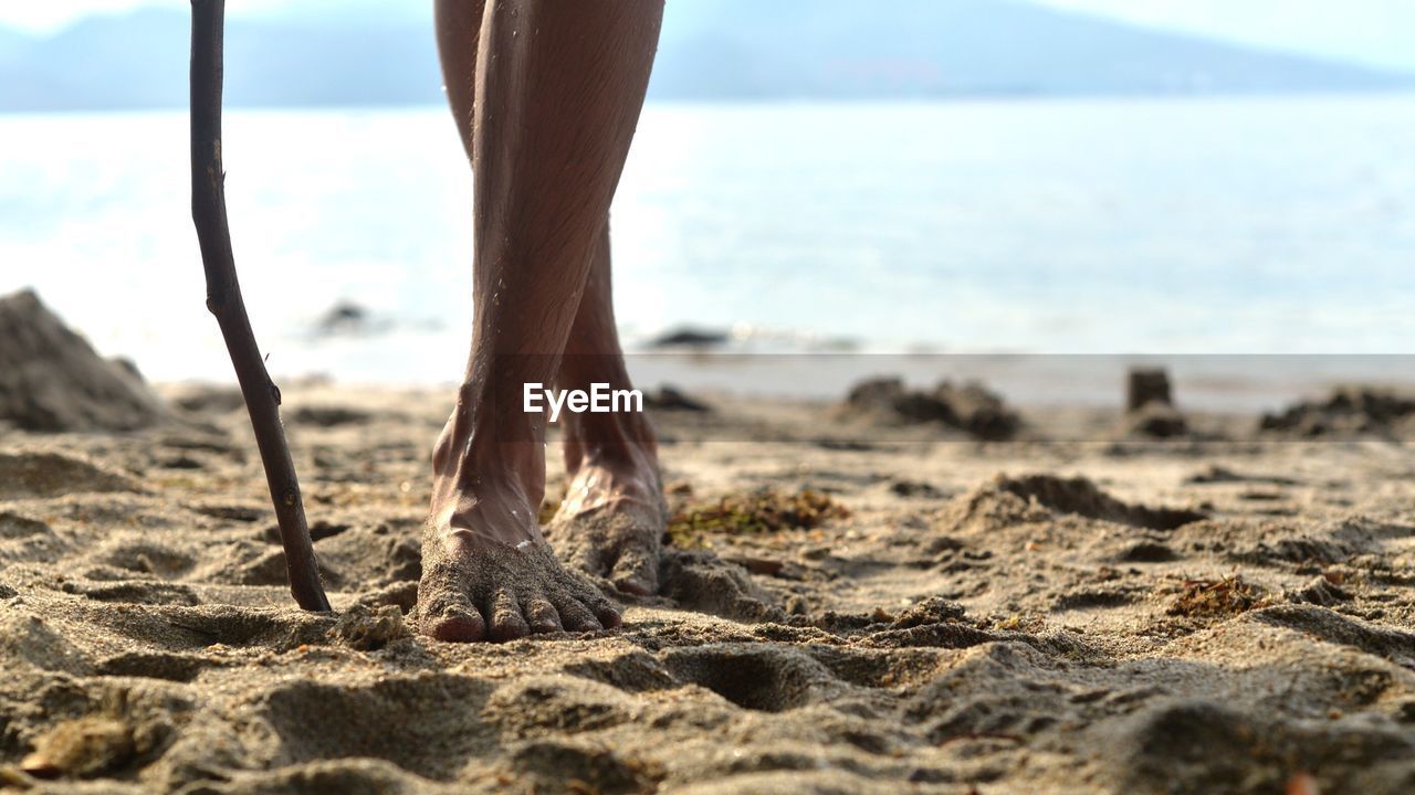 Low section of woman standing on beach