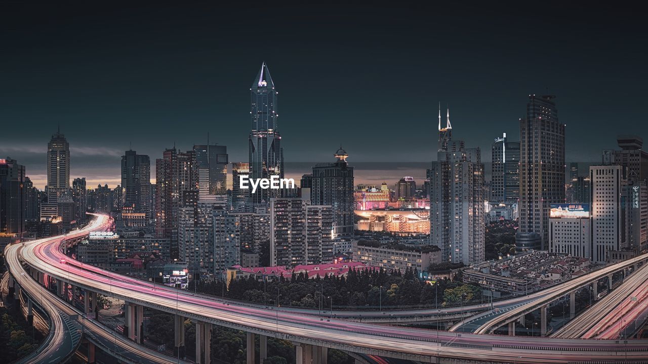 High angle view of illuminated highway amidst buildings in city at night