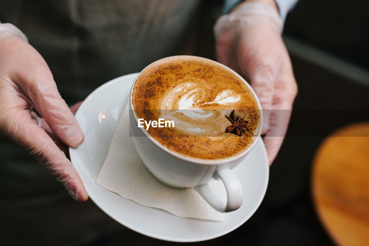 Midsection of man holding coffee cup