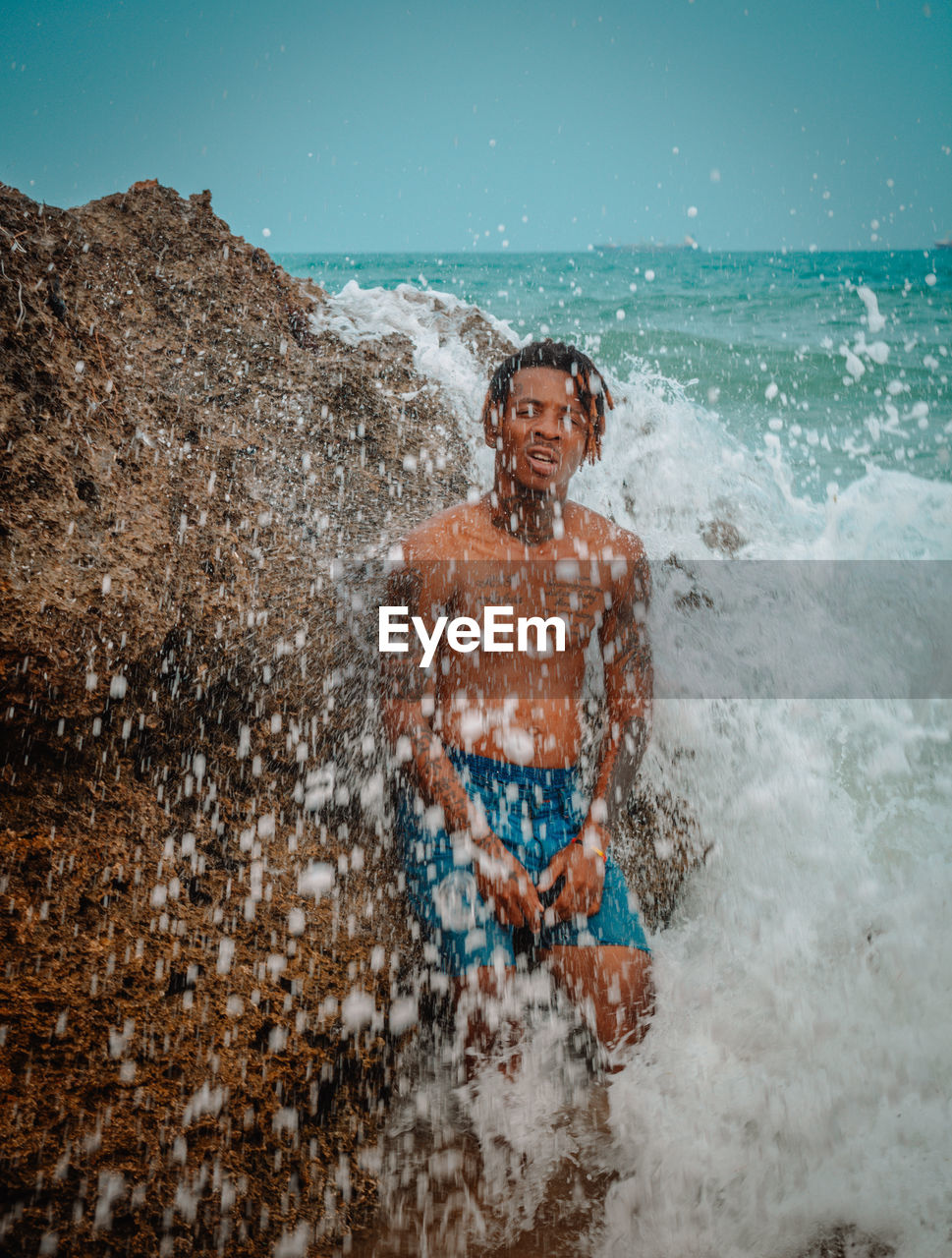 YOUNG MAN SURFING IN SEA