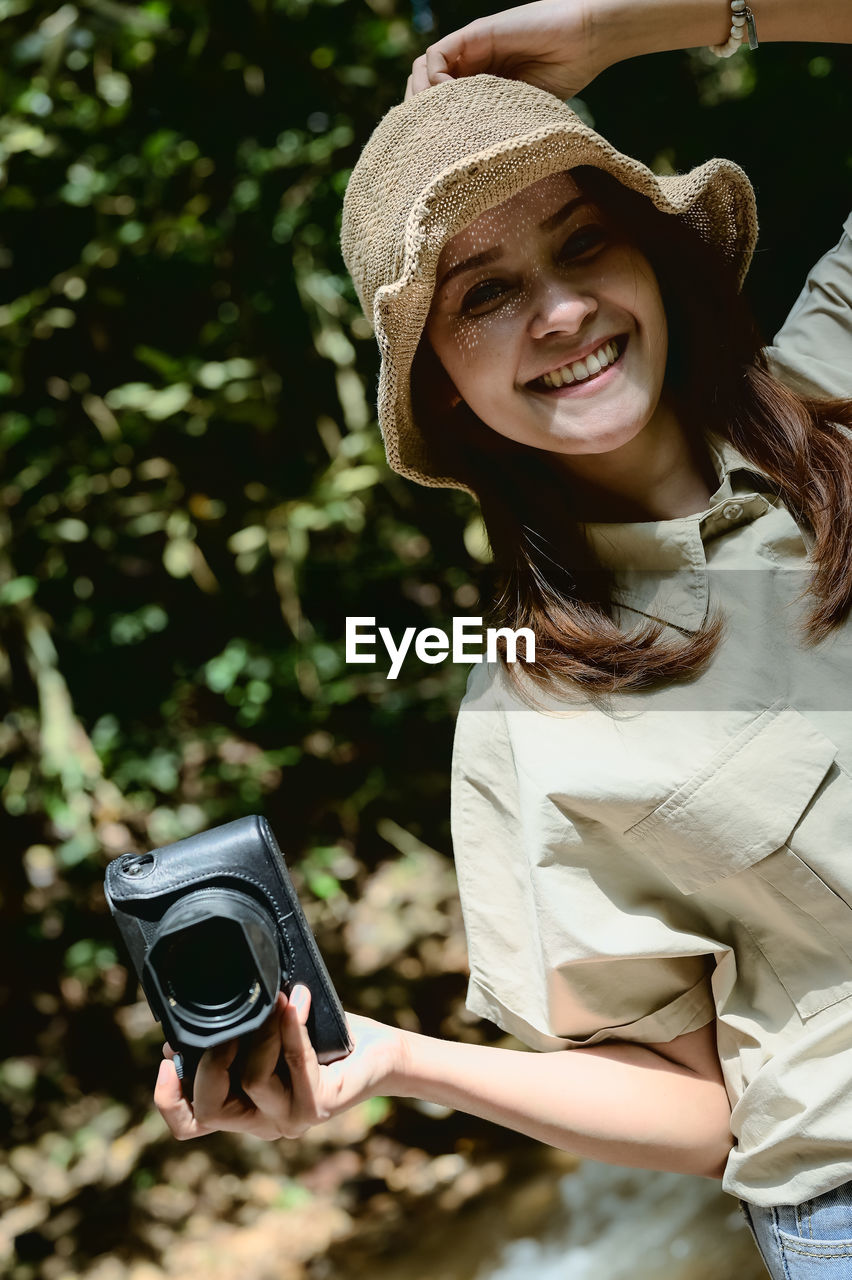 Young women photographer in enjoy emotion and hand holding camera