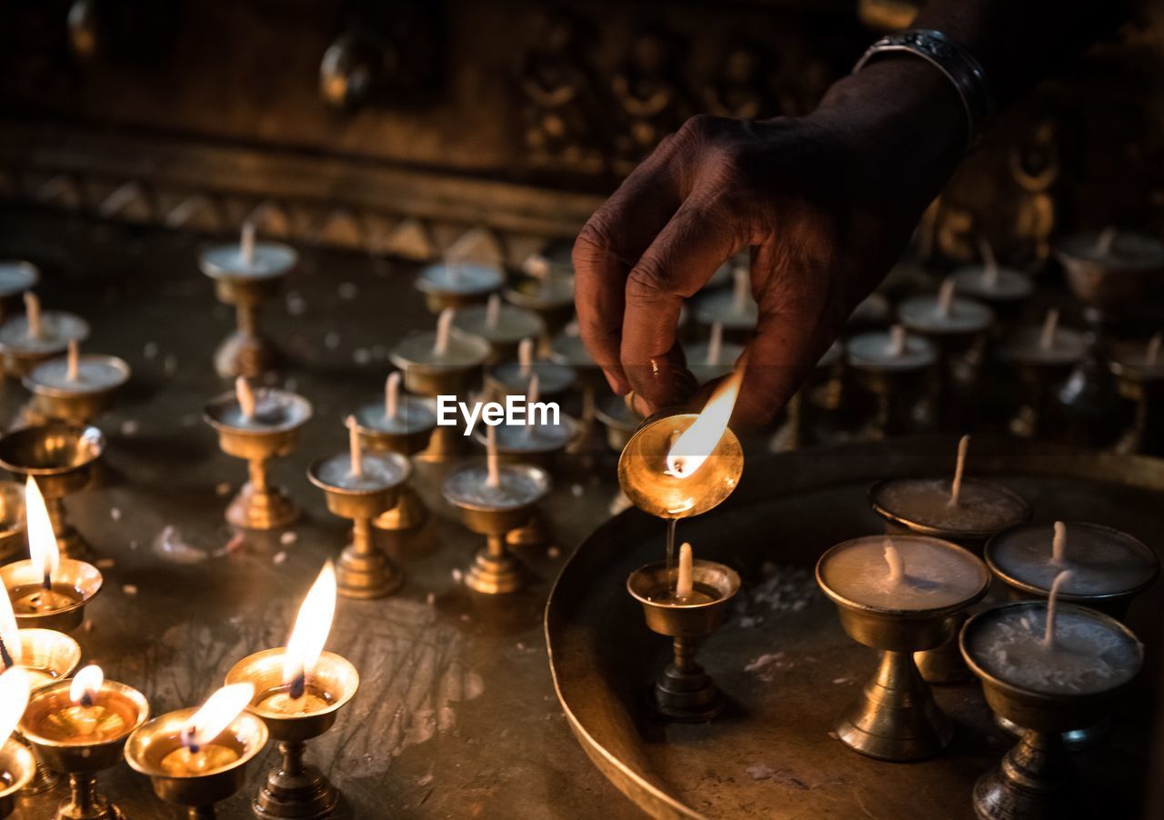 Cropped image of person pouring oil in diya