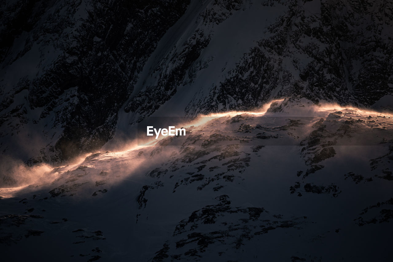 Aerial view of snow covered mountain during sunset