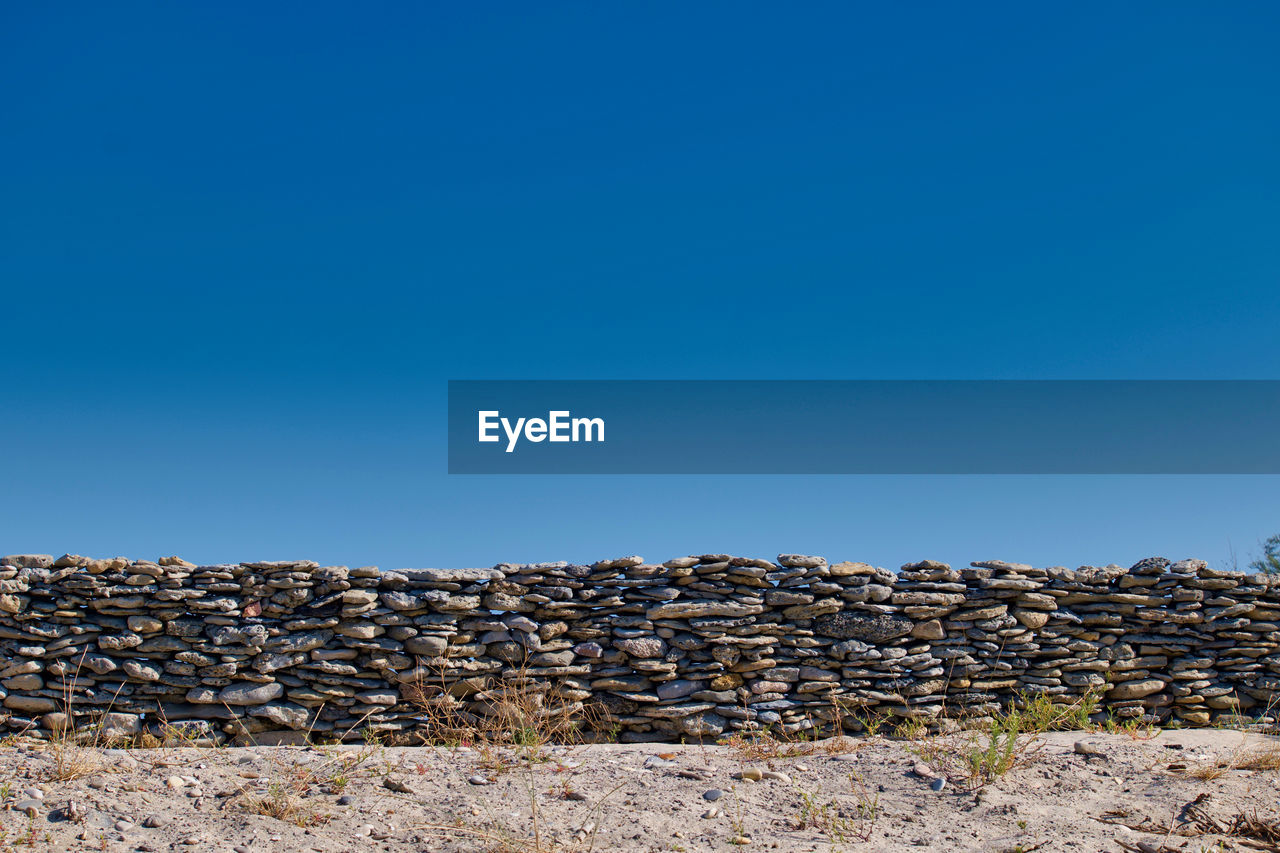 Stack of rocks against clear blue sky