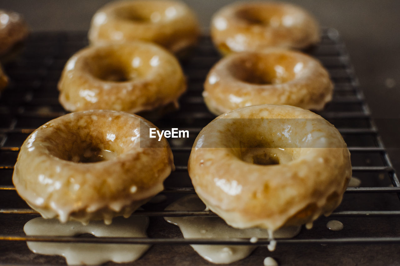 Iced doughnuts fresh out of the oven cooling on a wire rack