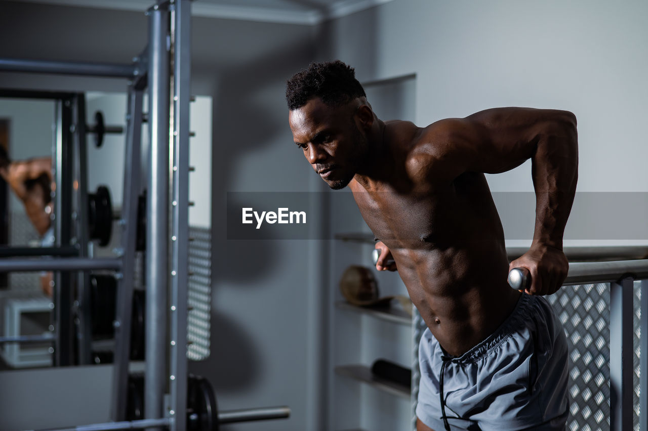 Shirtless athlete exercising in gym