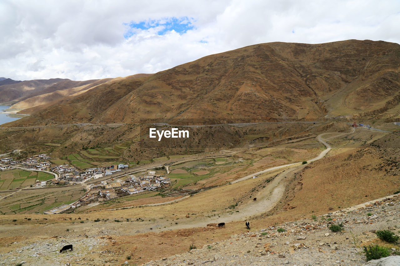 Barren landscape against cloudy sky