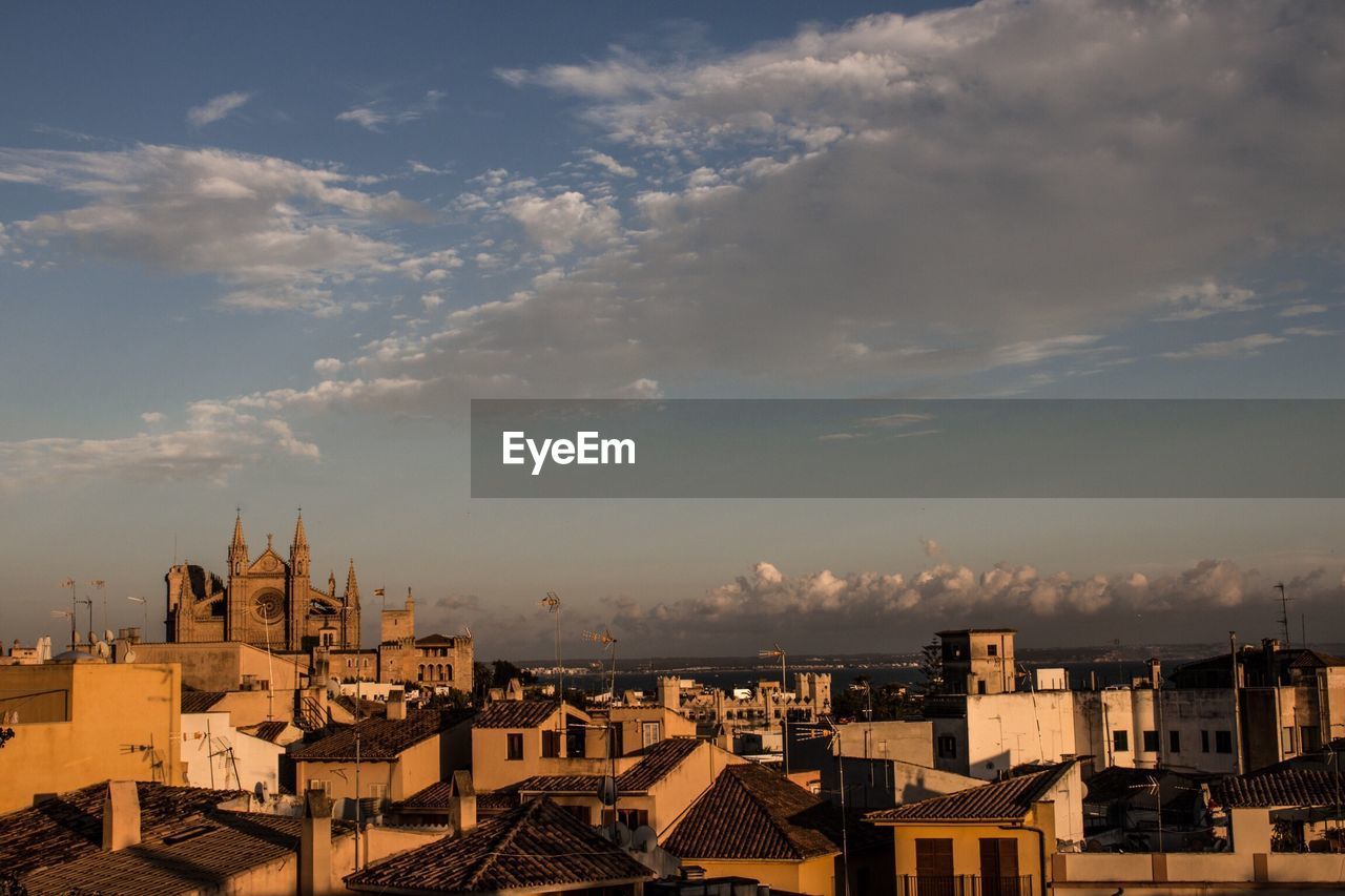 Cityscape against cloudy sky