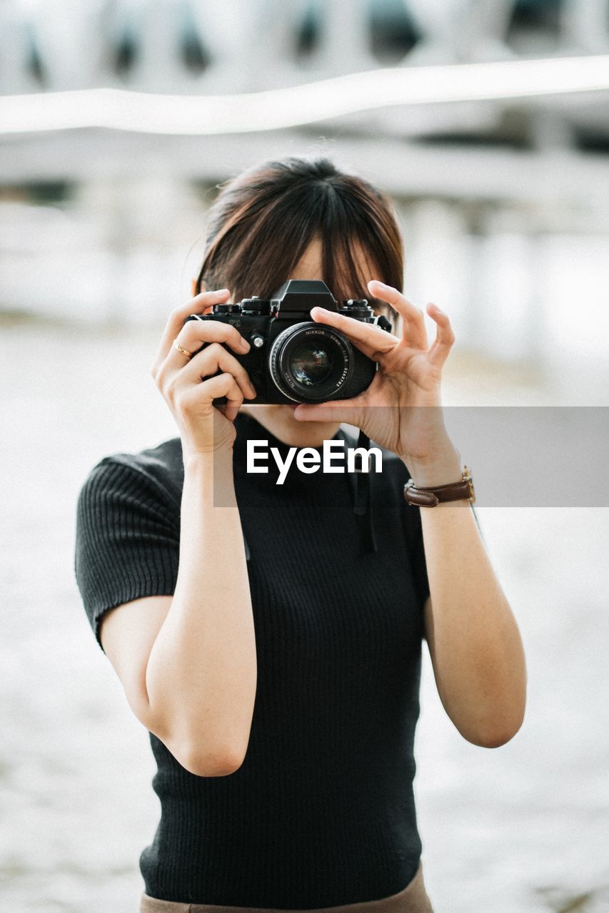 PORTRAIT OF YOUNG WOMAN PHOTOGRAPHING