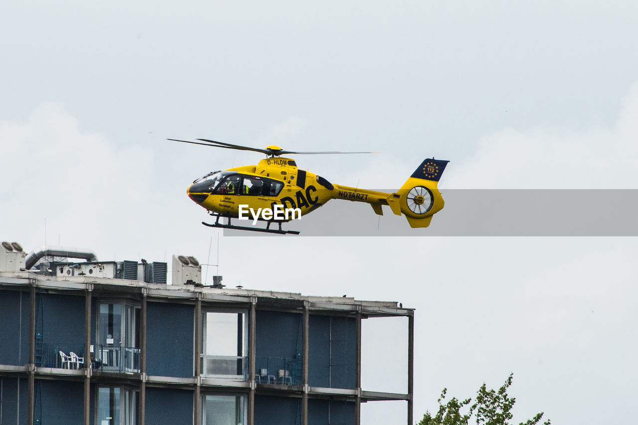 LOW ANGLE VIEW OF YELLOW FLAG ON BUILDING