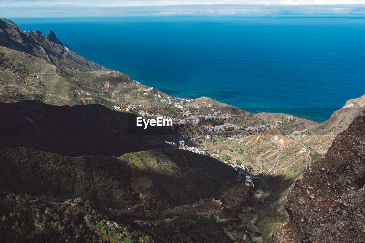 High angle view of sea and mountains against sky